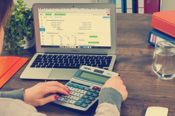 Woman Calculating Benefit of Custom Portfolio on Personal Finances