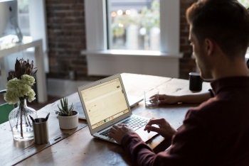 Man Checking Growth Oriented Portfolio Returns on Computer