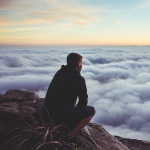 Man on Top of Mountain Representing New Vision for Legacy Portfolio Management